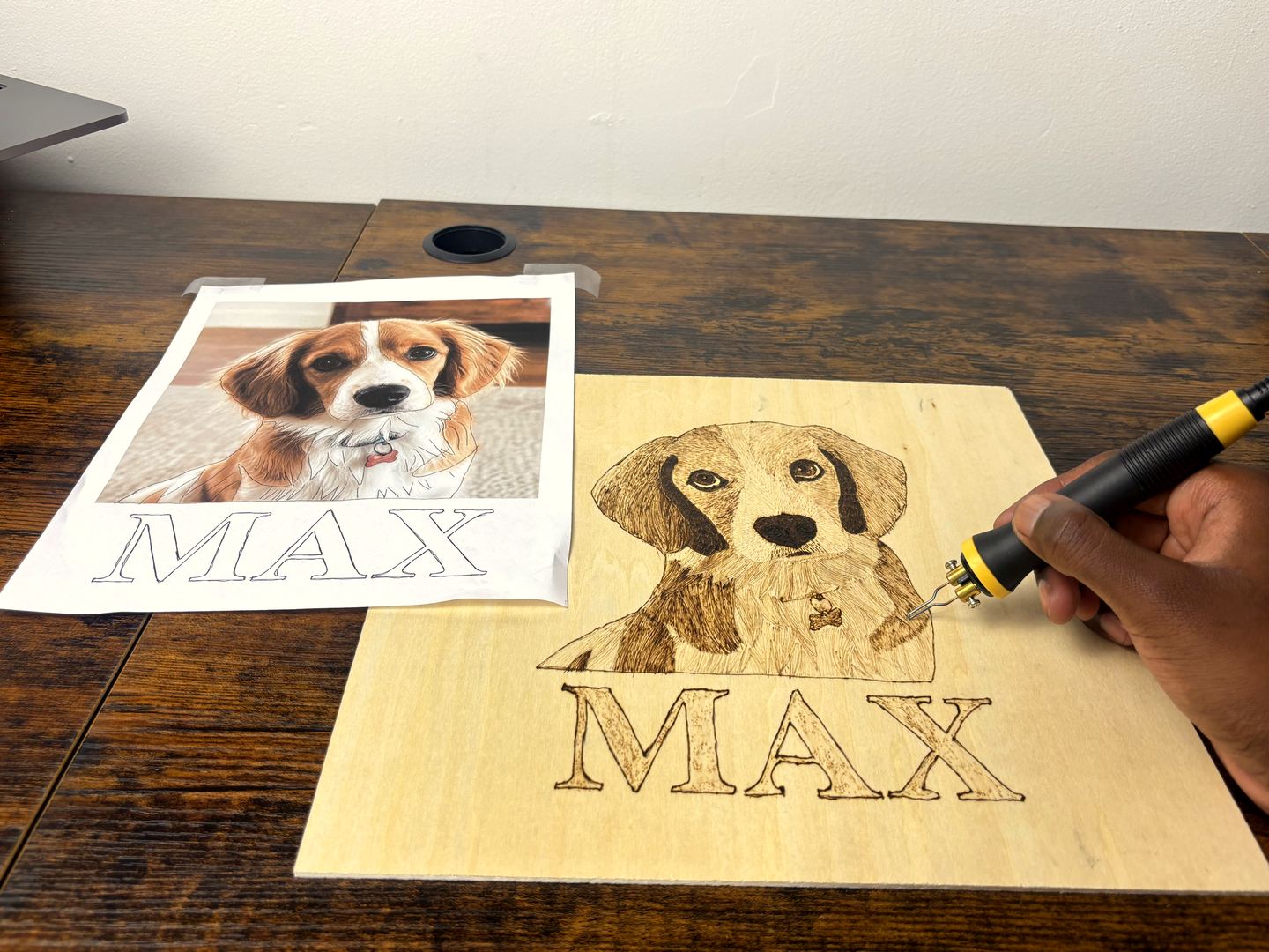 A hand burning a dog portrait into a slice of wood